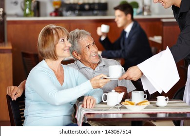 Happy Senior Couple Drinking Coffee At Coffee Shop In Hotel