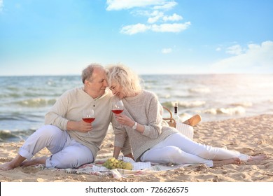 Happy Senior Couple Drinking Wine On Sea Beach