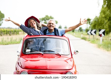 Happy Senior Couple Driving Vintage Car