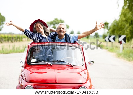 Happy senior couple driving vintage car