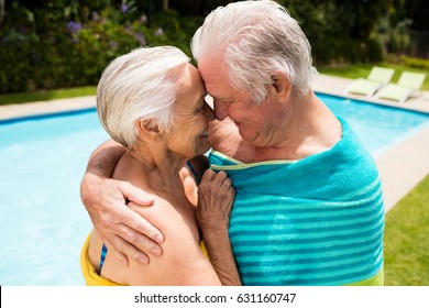 Happy senior couple embracing each other at poolside - Powered by Shutterstock