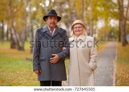 happy senior couple embracing at park during autumn