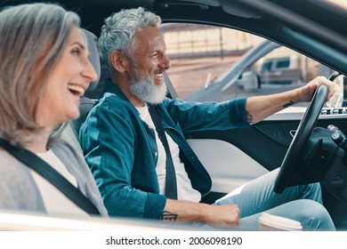 Happy senior couple enjoying car ride while sitting on front seats of the car - Powered by Shutterstock