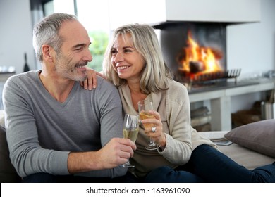 Happy Senior Couple Enjoying Glass Of Champagne