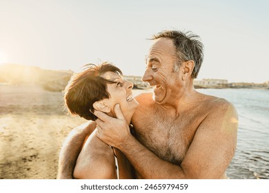 Happy senior couple enjoying vacations on the beach - Elderly people love concept - Powered by Shutterstock