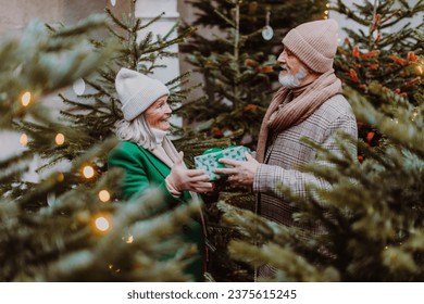 Happy senior couple exchanging Christmas gifts. - Powered by Shutterstock