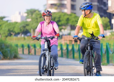 Happy  senior couple exercising with bicycles in the park - Powered by Shutterstock