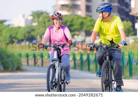 Happy  senior couple exercising with bicycles in the park