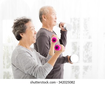 happy senior couple exercising with dumbbells  - Powered by Shutterstock