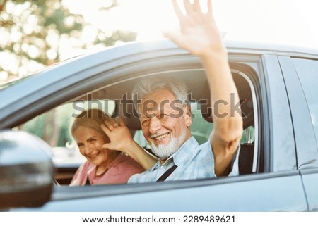 Happy senior couple going on a trip in their car