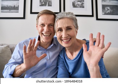 Happy Senior Couple Greeting Family Making Online Video Call Talking To Web Cam. Middle Aged Old Grandparents Waving Hands Enjoying Virtual Distance Meeting Chat Looking At Camera At Home, Webcam View