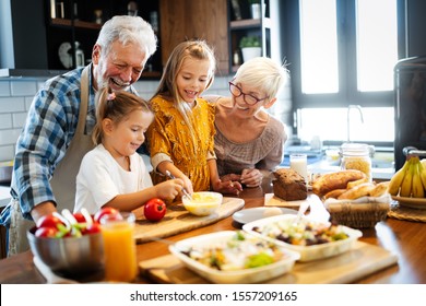 Happy senior couple having breakfast with their grandchildren at home