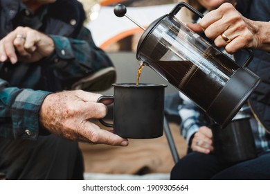 Happy senior couple having coffee by the tent in the forest - Powered by Shutterstock