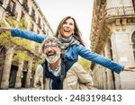 Happy senior couple having fun walking on city street - Two older tourists enjoying together weekend summer vacation - Life style, tourism and romance moments concept