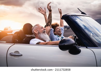 Happy senior couple having fun driving on new convertible car - Mature people enjoying time together during road trip tour vacation - Travel people lifestyle concept