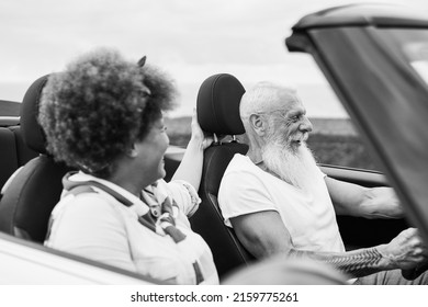 Happy Senior Couple Having Fun In Convertible Car During Summer Vacation - Focus On Man Face - Black And White Editing