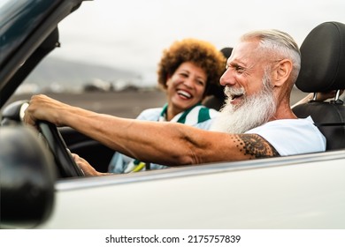 Happy senior couple having fun driving on new convertible car - Travel people lifestyle concept - Powered by Shutterstock