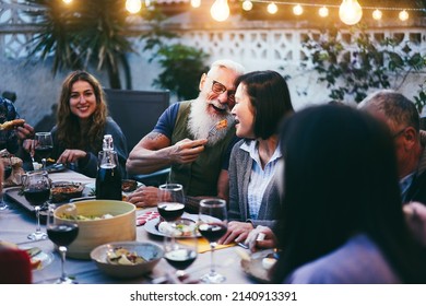 Happy Senior Couple Having Tender Moment At Barbecue Family Dinner - Focus On Man Hand Holding Fork