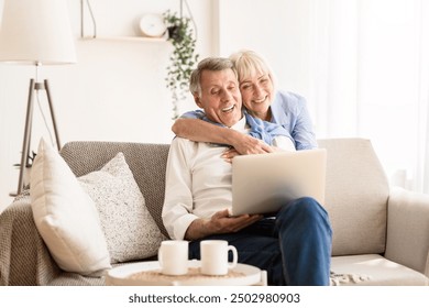 Happy senior couple having video call on laptop, talking with grandchildren and smiling - Powered by Shutterstock