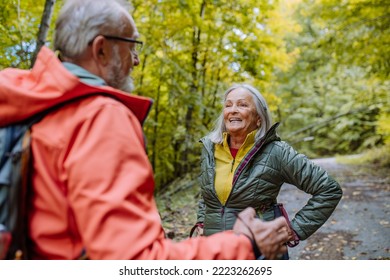 Happy Senior Couple Hiking In Autumn Forest.