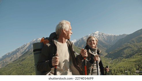 Happy senior couple hiking at the mountain on sunset - Powered by Shutterstock