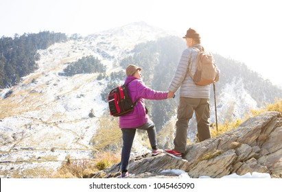 Happy Senior Couple Hiking On The Mountain