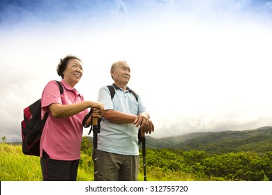 Happy Senior Couple Hiking On The Mountain