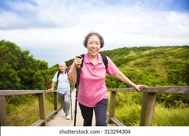 Happy Senior Couple Hiking On The Mountain