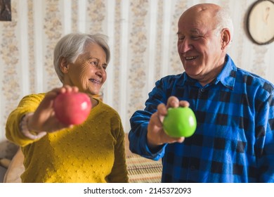 Happy Senior Couple Holding Apples Healthy Lifestyle Concept Medium Closeup Living Room. High Quality Photo