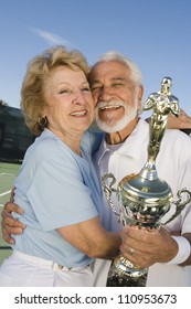 Happy Senior Couple Holding Trophy After Winning