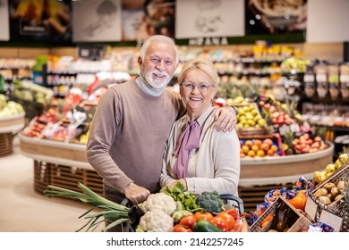 Happy senior couple hugs and smiles at the camera while shopping in supermarket. - Powered by Shutterstock