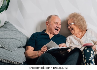 Happy senior couple laughing in bed at home.Cheerful senior woman with husband in nightwear at home