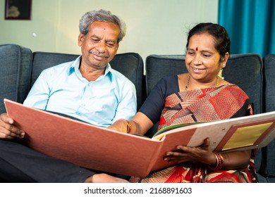 Happy Senior Couple Laughing By Looking Into To Marriage Photo Album - Concept Of Old Memories, Nostalgic And Family Bonding