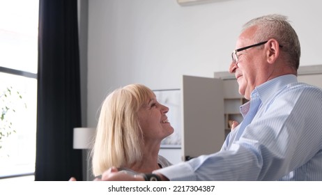 Happy Senior Couple In Love Dancing In The Living Room, In The Kitchen.