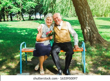 Happy Senior Couple Love Story. Old Couple Is Walking In The Green Park. Grandmother And Grandfather Laughing. Elderly People Lifestyle. Together Pensioners.