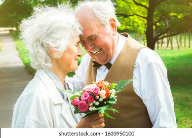 Happy senior couple love story. Old couple is walking in the green park. Grandmother and grandfather laughing. Elderly people lifestyle. Together Pensioners. - Powered by Shutterstock