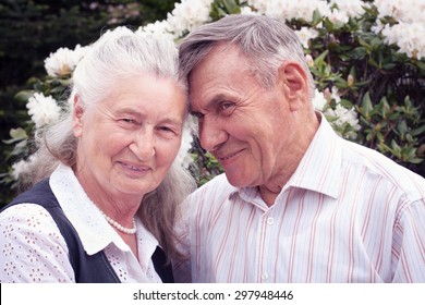 Happy Senior Couple Lying In Park In Spring. Authentic Emotions