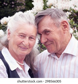 Happy Senior Couple Lying In Park In Spring. Authentic Emotions