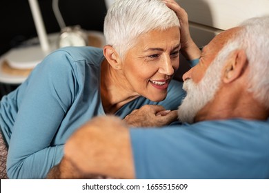 Happy senior couple lying together in bed - Powered by Shutterstock