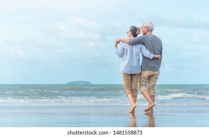 Happy Senior Couple On The Beach. Exotic Luxury Resort.back View.