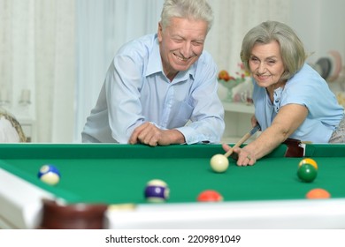 Happy Senior Couple Playing Billiards On Vacation Together In Home