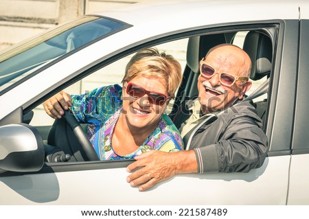 Happy senior couple ready for driving a car on a journey trip - Concept of joyful active elderly lifestyle with man and woman enjoying their best years