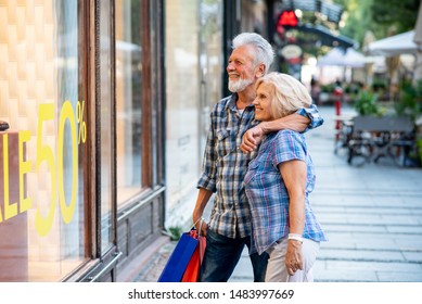 Happy Senior Couple In Shopping Looking At Window