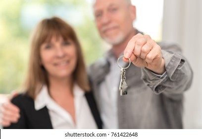 Happy senior couple showing house keys - Shutterstock ID 761422648