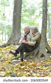 Happy Senior Couple Sitting On Bench