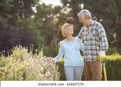 Happy senior couple standing in backyard - Shutterstock ID 654437170