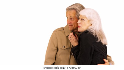 Happy Senior Couple Staying Warm And Standing In Front Of White Background