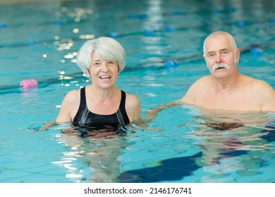 Happy Senior Couple Swimming In The Pool