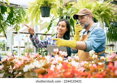 Happy senior couple taking care of flowers in plants nursery and talking to each other. Garden checklist order via walkie talkie in plants market - Powered by Shutterstock