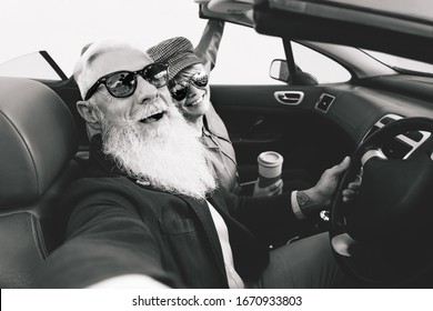 Happy Senior Couple Taking Selfie On New Convertible Car - Mature People Having Fun Together During Road Trip Vacation - Elderly Lifestyle And Travel Transportation Concept - Black And White Editing